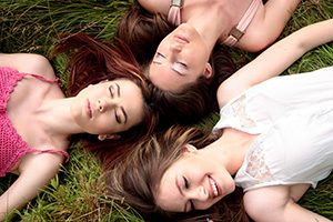girls laying in the grass meditating