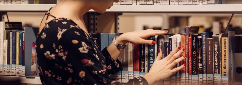 Student browsing selection of foreign language books in college library