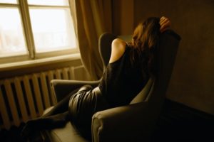 woman curled up in chair struggling with adjustment disorder