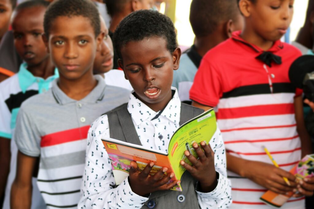 Man with verbal dyslexia in red and white polo shirt holding yellow book